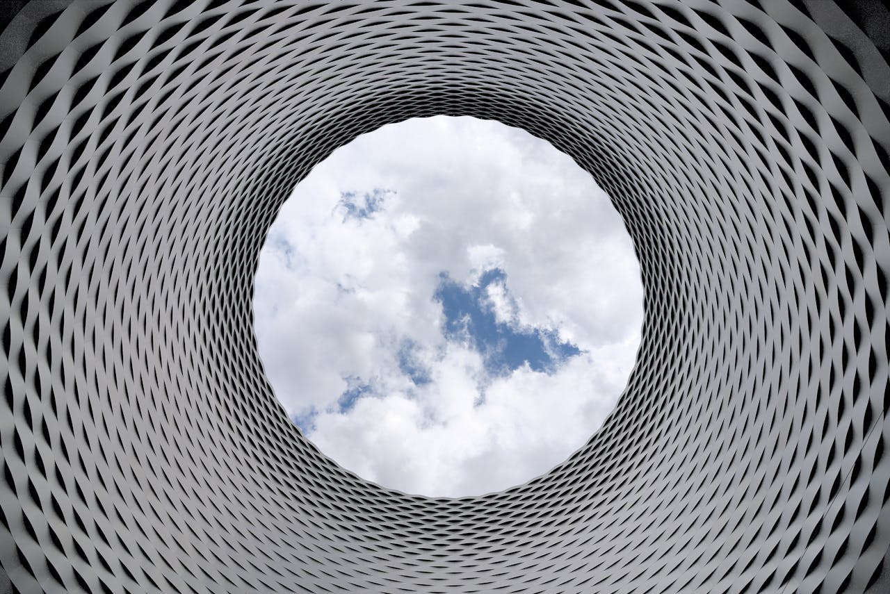 Mastering the First Impression: Your intriguing post title goes here Modern architectural tunnel with a geometric pattern revealing a bright sky.